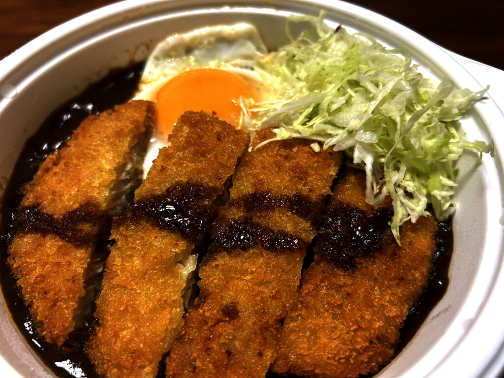 小盛でもボリューム満点なゴーゴーカレーのロースカツカレーと半熟目玉焼き、千切りキャベツ