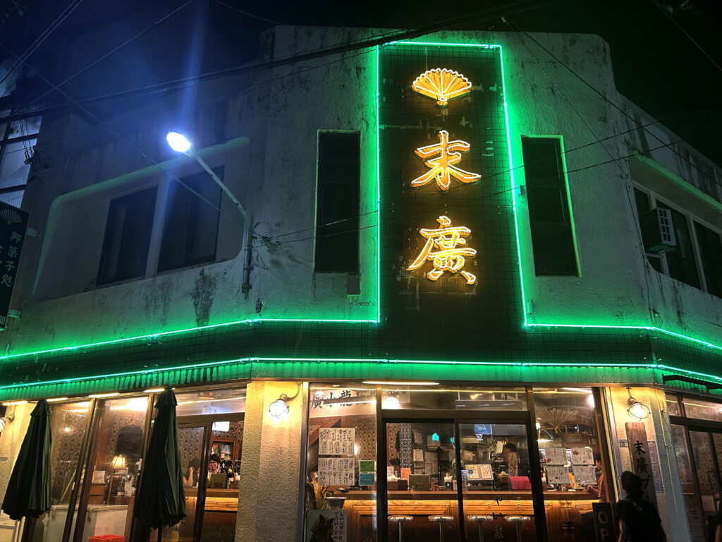 那覇市松尾の浮島通りエリアにある居酒屋「末廣ブルース」の緑ネオンが輝くレトロな外観