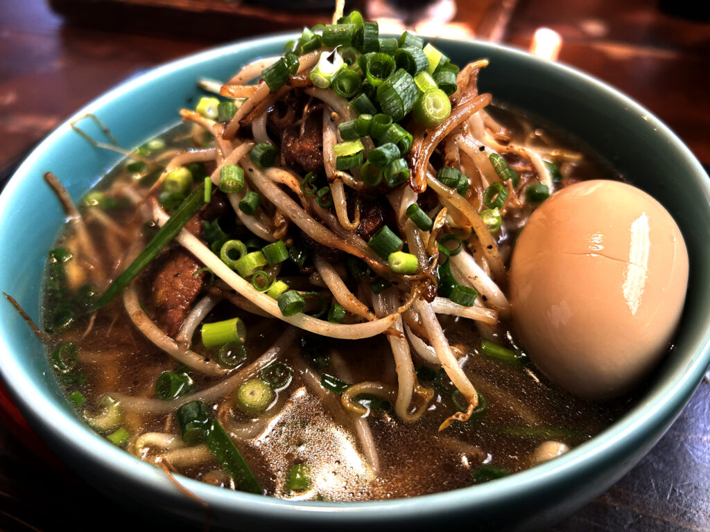 炒めた牛もやしとネギが山盛りにのったOKINAWA SOBA EIBUNの牛もやしそば味玉トッピング